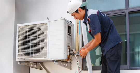HVAC technician  checking an outdoor AC unit